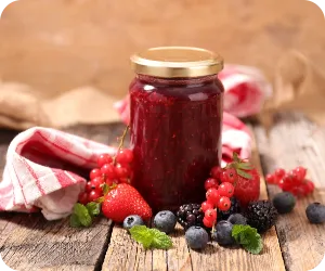 フルーツが周りに飾ってあるジャムの瓶の写真